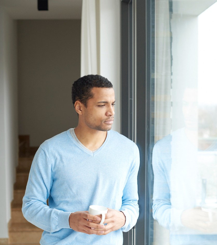 A man pausing with a cup of coffee, a quiet moment of reflection before choosing how to respond